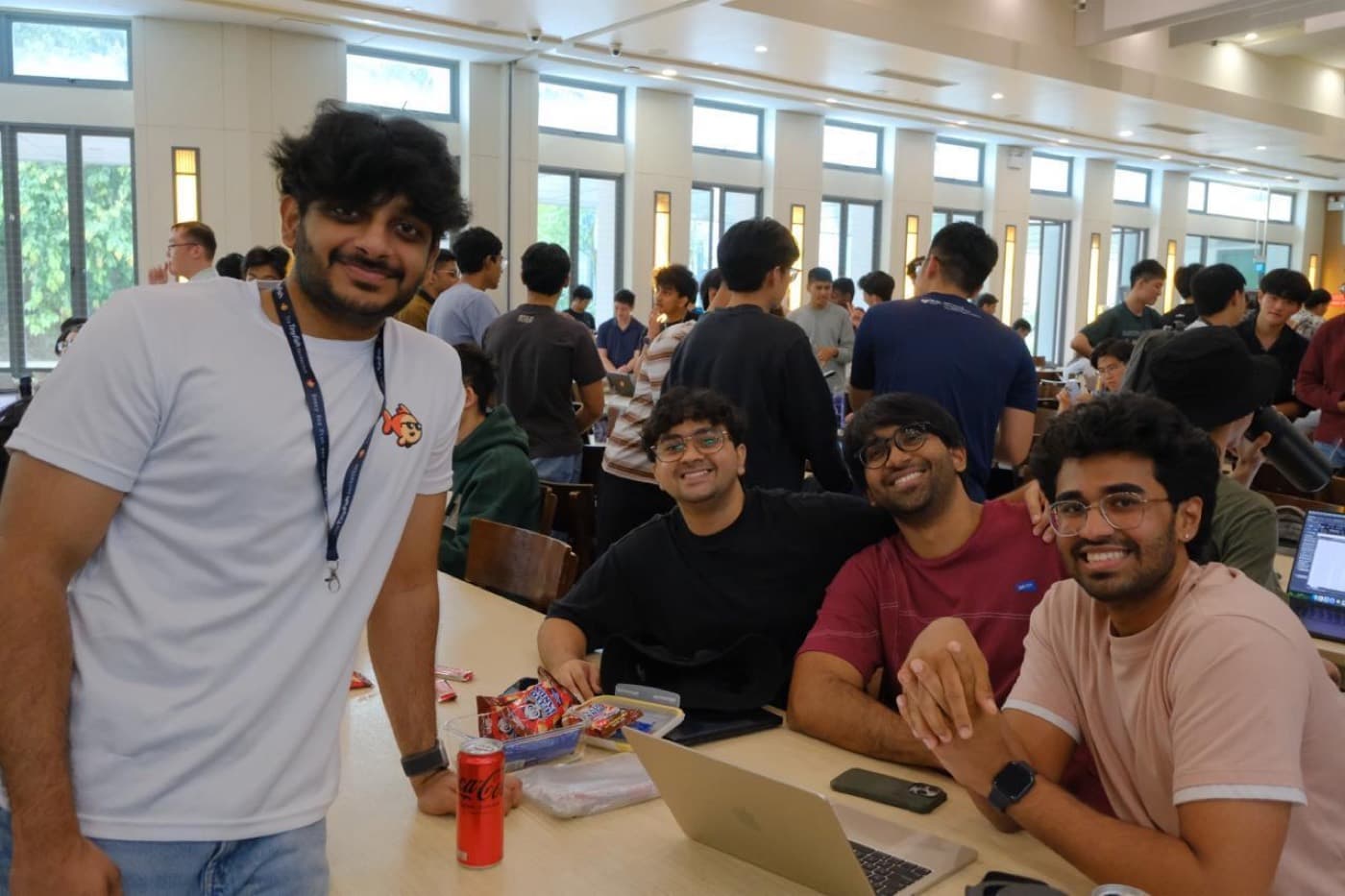 A group of students around a laptop, laughing